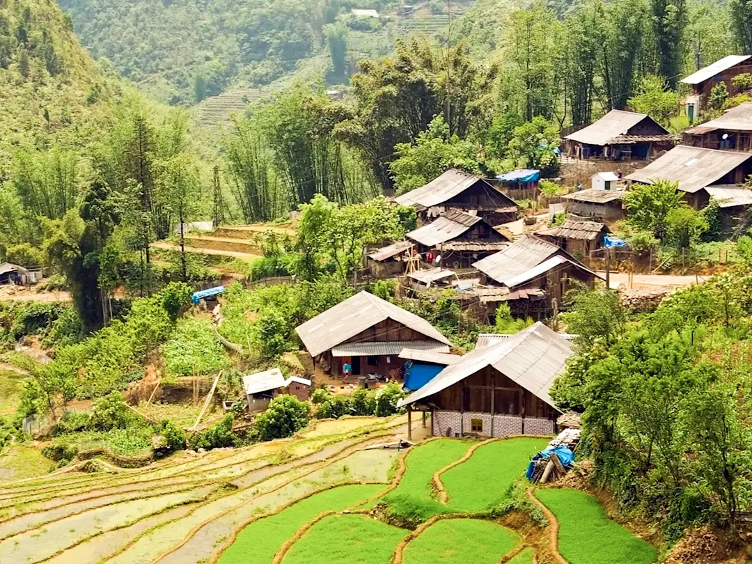 Traditionelles Bergdorf mit Reisterrassen in grüner Landschaft. Sa Pa, Lào Cai, Vietnam.
