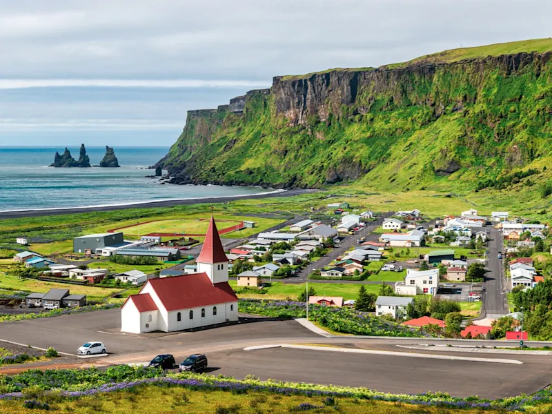 Vík í Mýrdal, Island Blick auf Vík í Mýrdal mit Kirche, Küste und Felsen, Südküste, Island.
