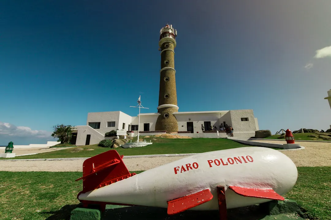 Uruguay, Cabo Polonio Petit avion rouge et blanc avec le phare en arrière-plan, à Cabo Polonio, en Uruguay