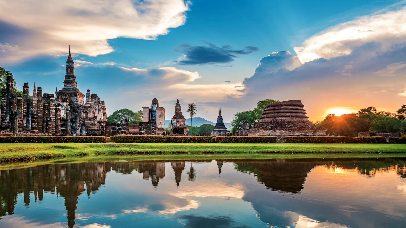 Sukothai Thailand Historische Tempelruinen spiegeln sich im Wasser bei Sonnenuntergang. Sukhothai, Thailand.