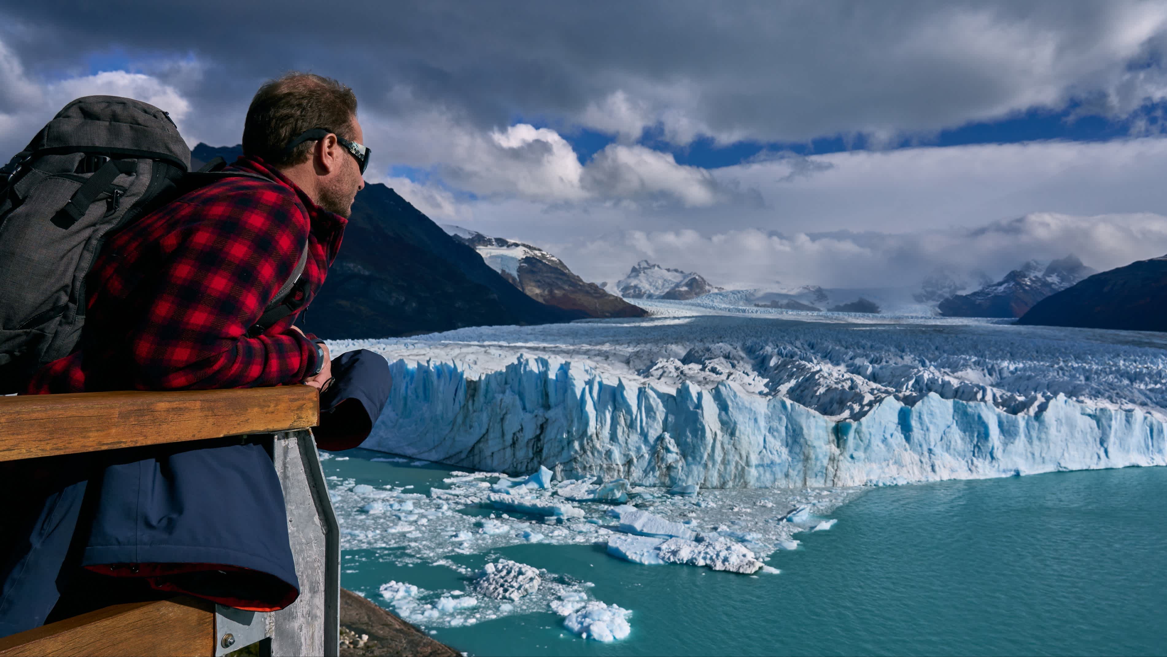 Un randonneur en tenue de marche contemple le glacier Perito Moreno en Argentine.