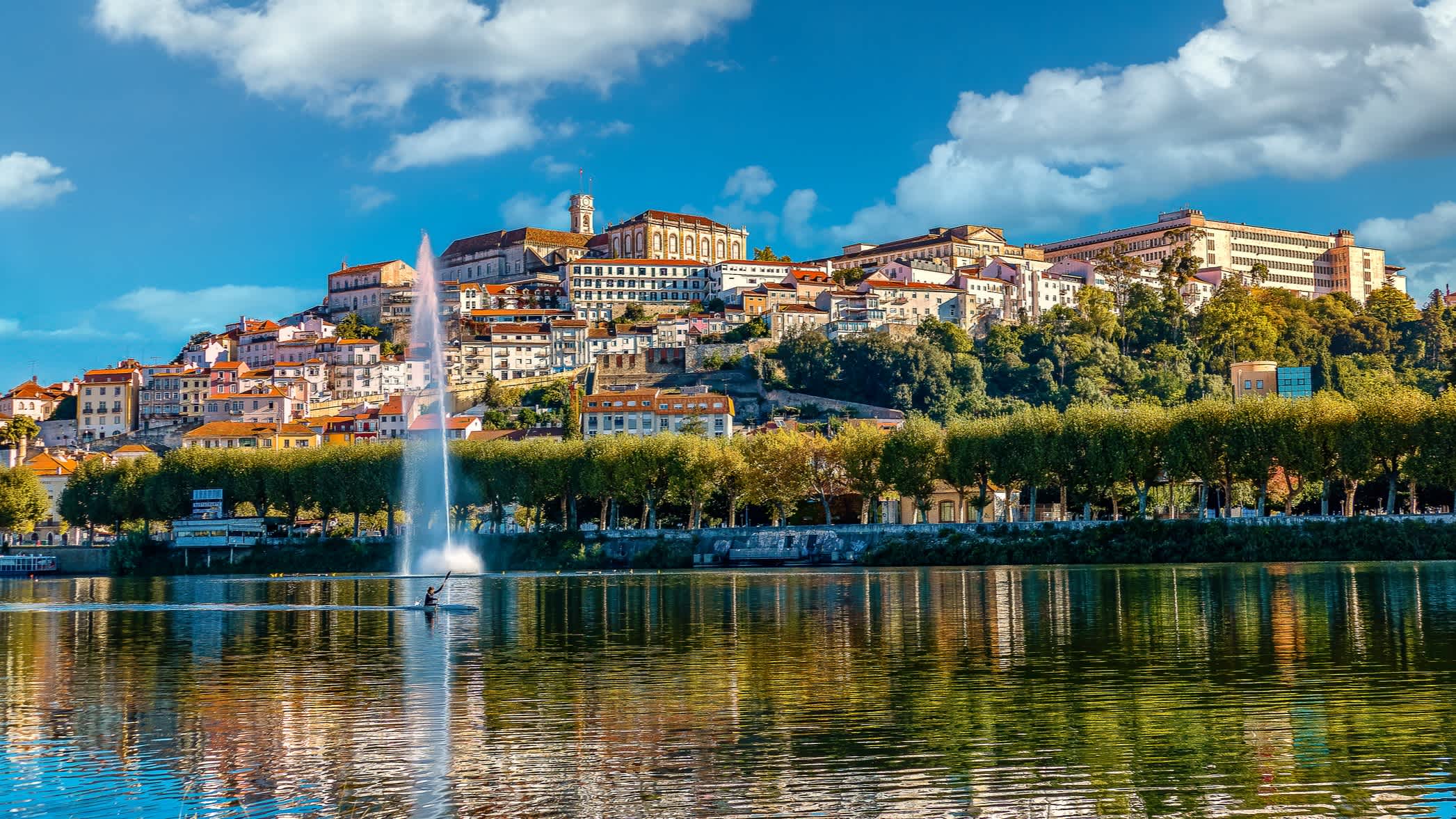 Blick auf die Stadt Coimbra vom Fluss aus mit Kanufahrer