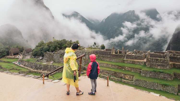 Vater und Tochter blicken auf Ruinen während einer Familienreise in Peru