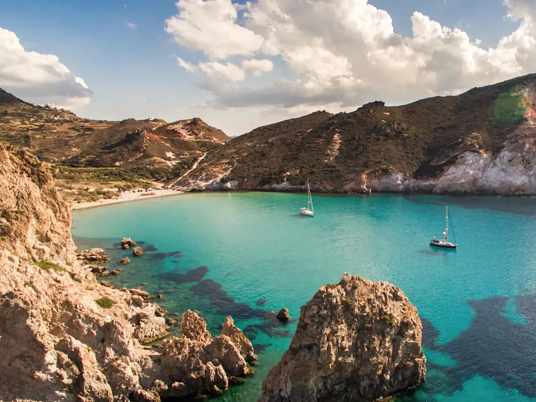 Türkisblaue Bucht mit Segelbooten und Felsformationen. Milos, Kykladen, Griechenland.