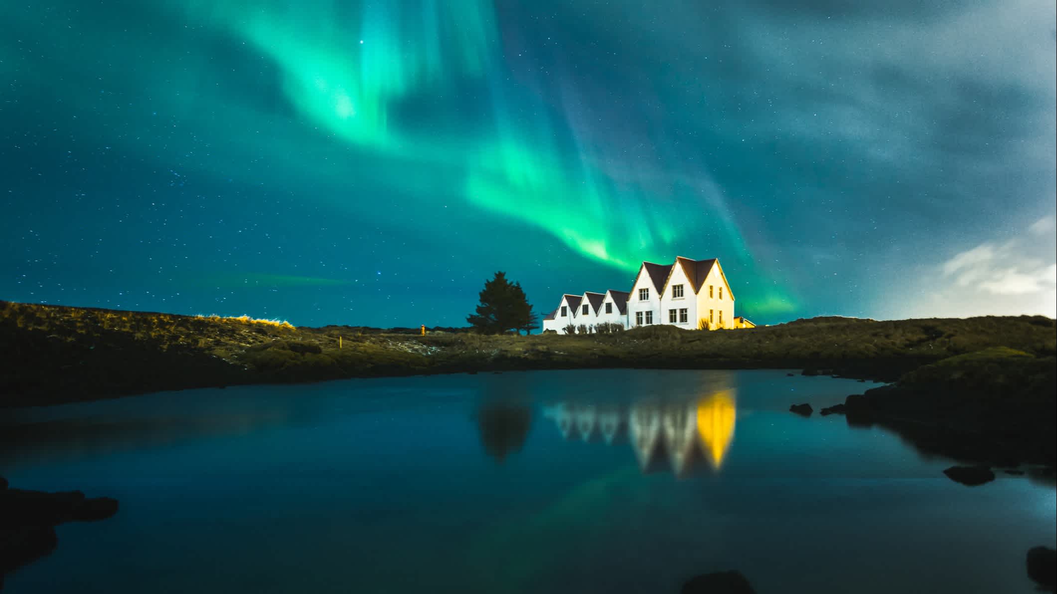 Maisons isolées sous les aurores boréales à Keflavik en Islande.