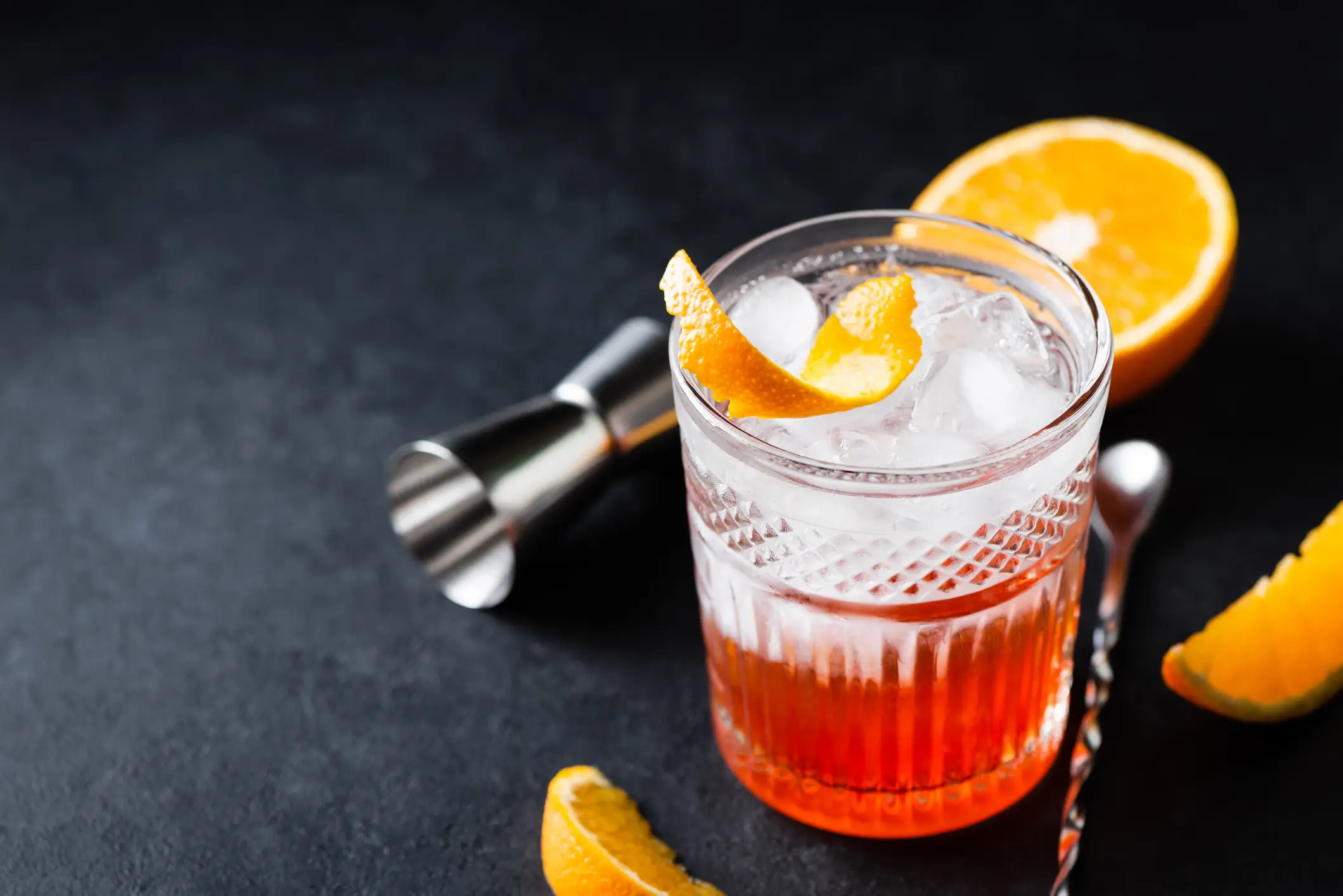 Cocktail orange Altmodischer alkoholischer Cocktail mit Orange auf schwarzem Steinhintergrund