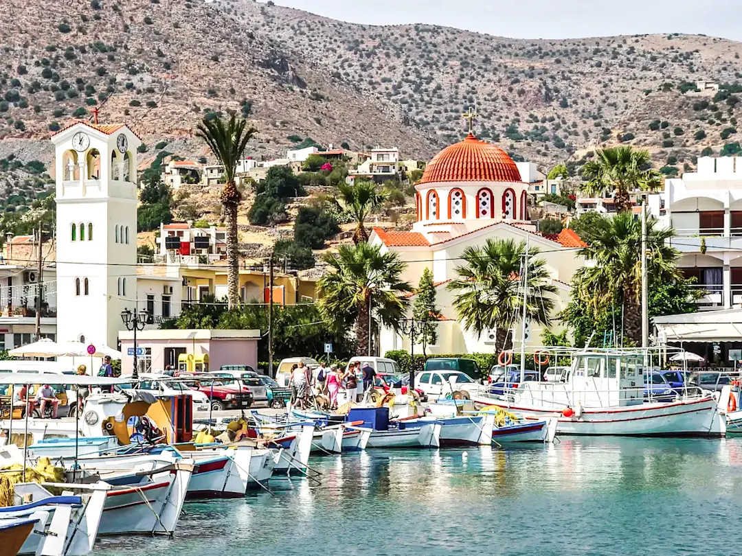 Griechenland, Kreta, Elounda Hafenstadt mit traditioneller Kirche und Fischerbooten. Elounda, Kreta, Griechenland.