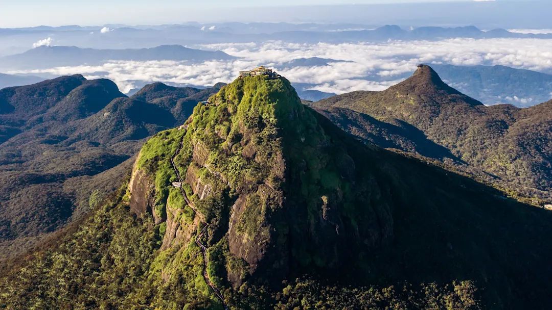 Luftaufnahme des Adams Peak mit Tempel auf dem Gipfel, umgeben von grünen Bergen. Nuwara Eliya, Zentralprovinz, Sri Lanka.

