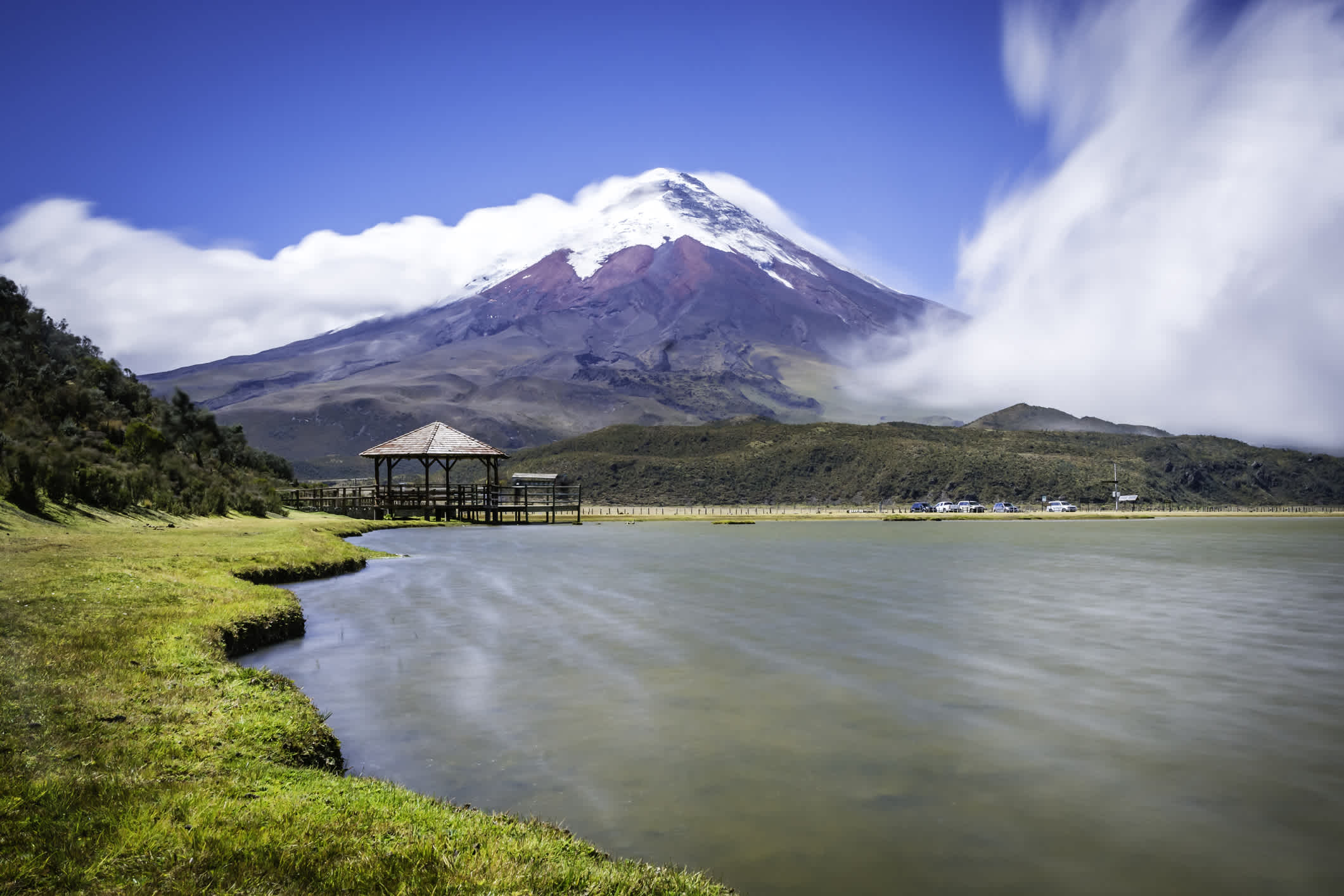 Pavillon en bois au pied de la montagne avec le Volcan Cotopaxi en arrière-plan, en Équateur.
