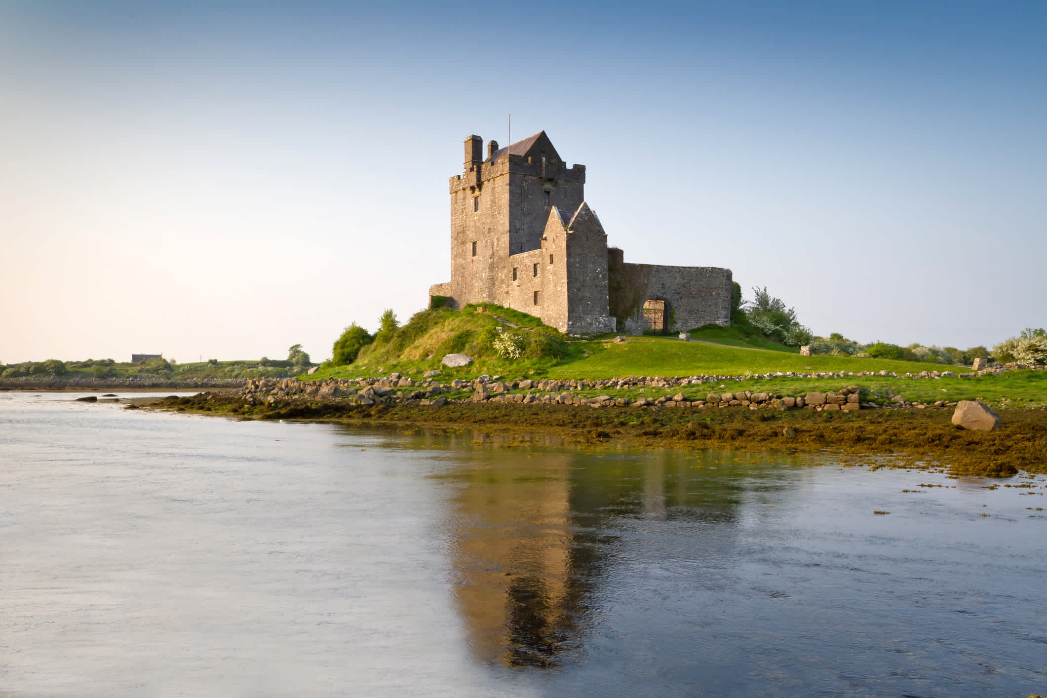 Blick auf das Dunguaire Castle aus dem 15. Jahrhundert in Galway mit Wasserspiegelung