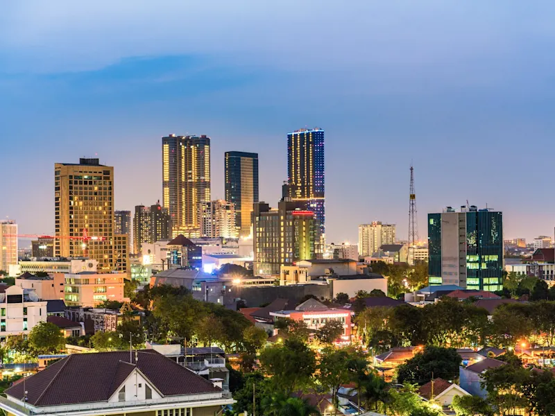 Surabaya, Java, Indonesien Beleuchtete Skyline von Surabaya mit modernen Hochhäusern bei Dämmerung. Surabaya, Java, Indonesien.