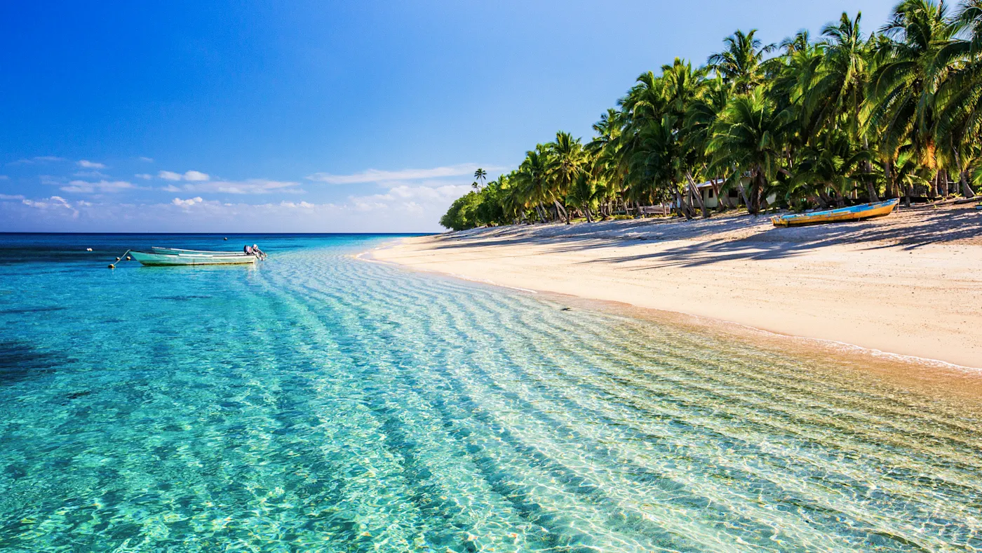 Viti Levu, Fidschi Weiße Sandstrand mit türkisblauem Wasser und Palmen am Ufer. Viti Levu, Fidschi