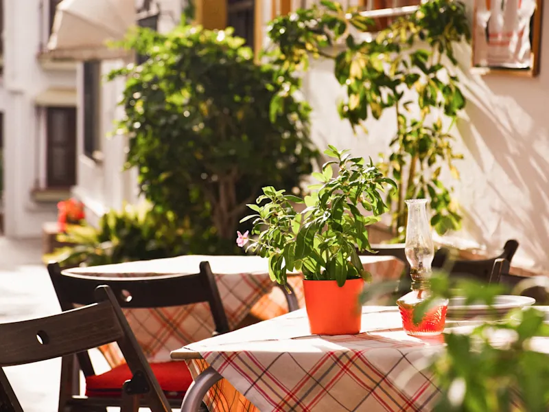 Marbella, Andalusien, Spanien Gemütlicher Außenbereich eines Restaurants mit Pflanzen und Sonnenschein. Marbella, Andalusien, Spanien.