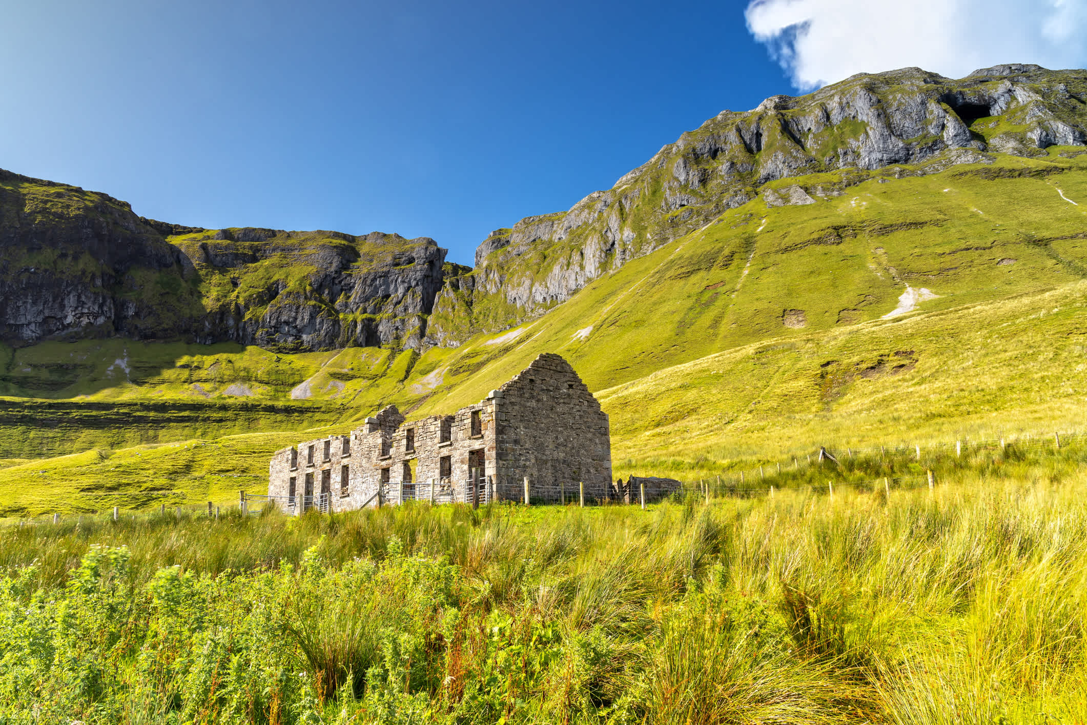 Vue sur une maison en ruine au milieu de la végétation en bas des montagnes, à Sligo en Irlande