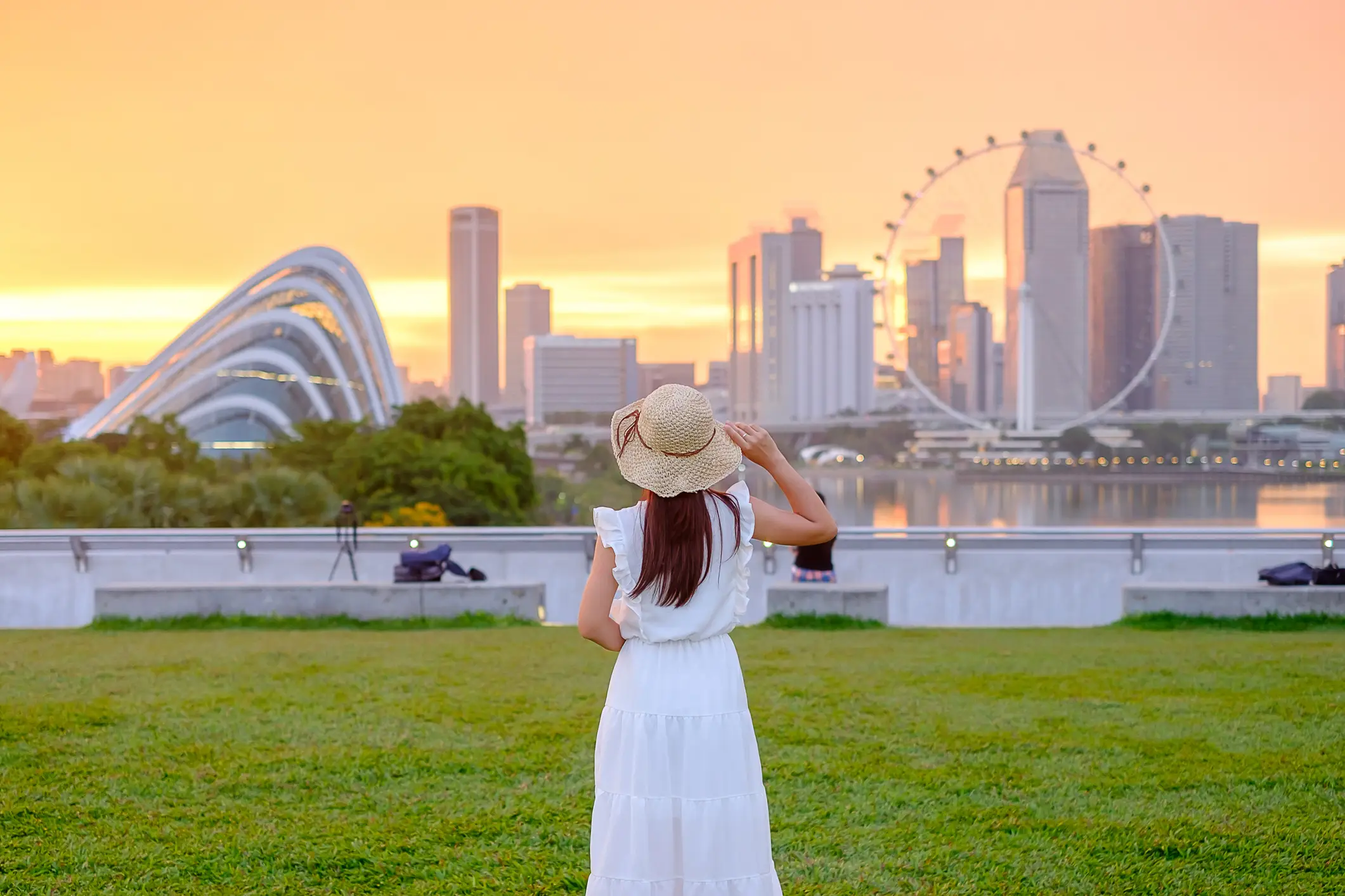 Singapur Junge Frau mit Hut bei Sonnenuntergang in Singapur Stadtzentrum.