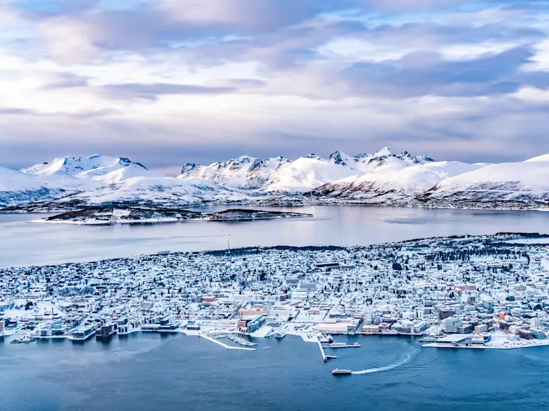 Winterlandschaft mit verschneiter Stadt und Fjordpanorama. Tromsø, Troms, Norwegen