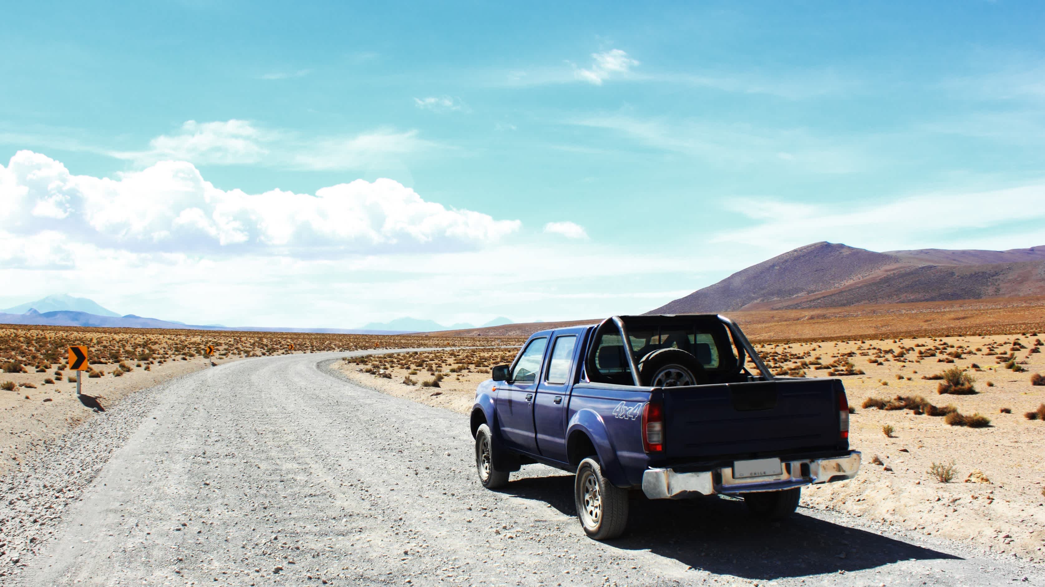 Un 4x4 à l'arrêt sur une route en plein milieu du désert pendant un voyage au Chili.