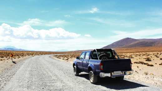 Un 4x4 à l'arrêt sur une route en plein milieu du désert pendant un voyage au Chili.