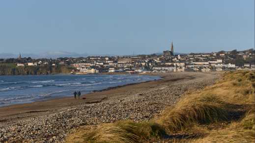 Strand mit Stadt im Hintergrund, Waterford, Irland.

