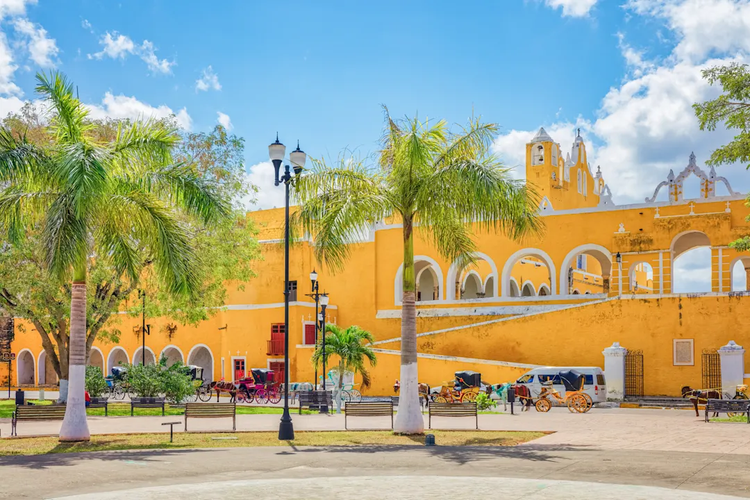 Koloniales Kloster mit gelben Bögen unter blauem Himmel. Izamal, Yucatán, Mexiko.
