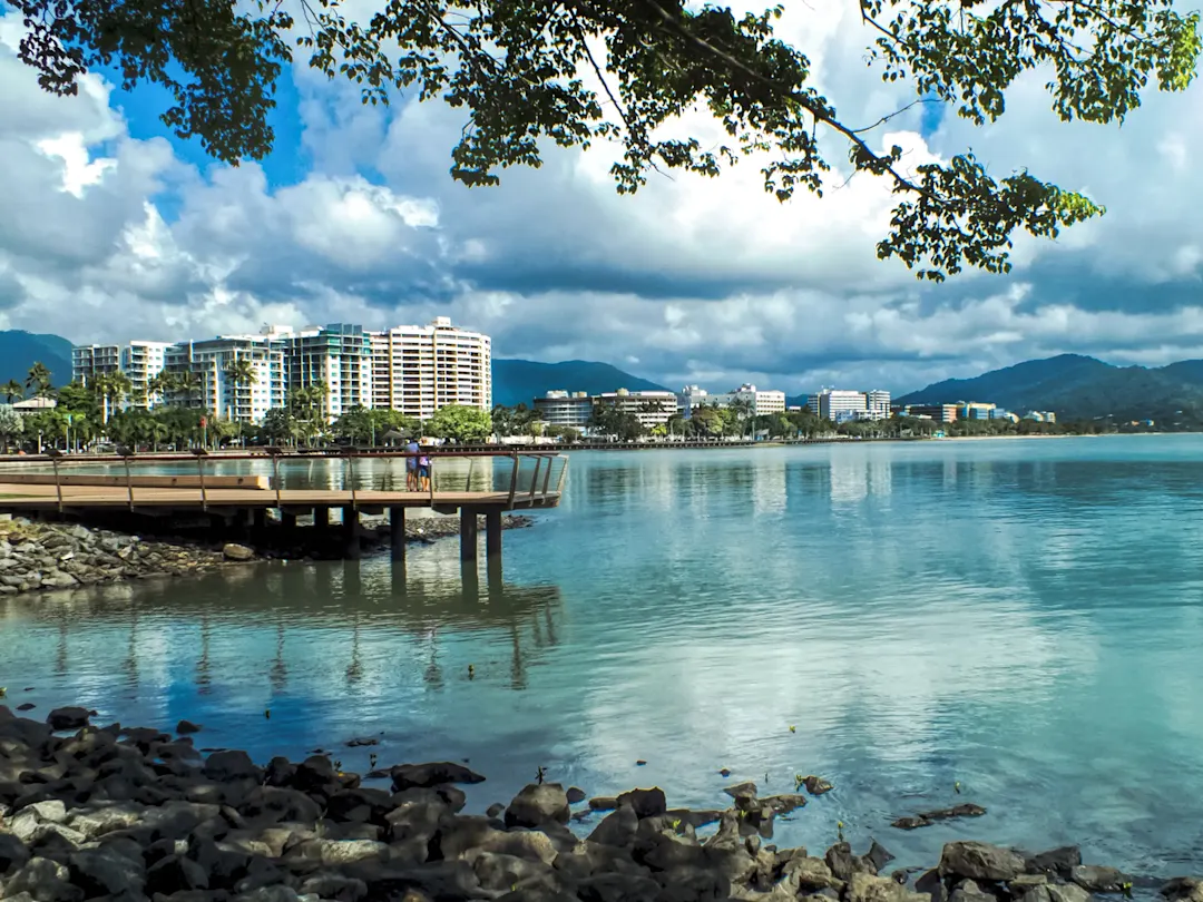 Moderne Promenade mit Blick auf das blaue Wasser und Hochhäuser. Cairns, Queensland, Australien.
