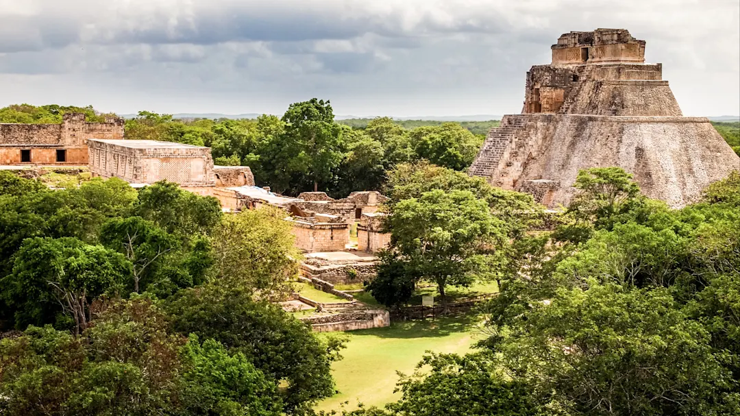 Luftaufnahme der Maya-Ruinen von Uxmal mit grüner Vegetation und dem Tempel des Zauberers. Uxmal, Yucatán, Mexiko.