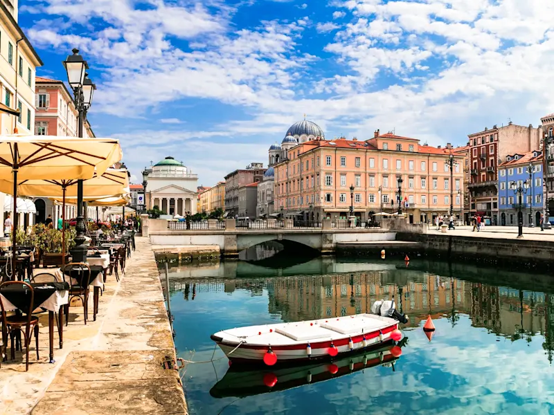 Canal pittoresque avec bâtiments colorés et bateau. Trieste, Italie.