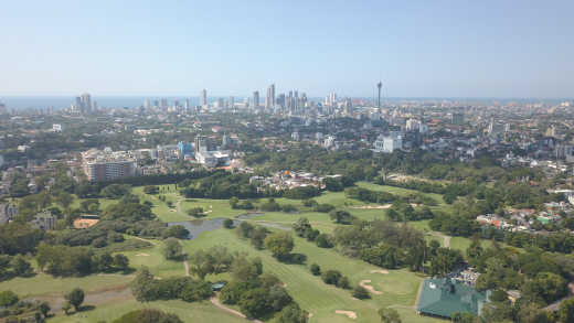 Luftaufnahme über Colombo mit Golfplatz und Skyline im Hintergrund