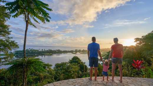 Eltern mit ein Kind beobachten den Sonnenaufgang im Corcovado Nationalpark, Osa-Halbinsel, Costa Rica.
