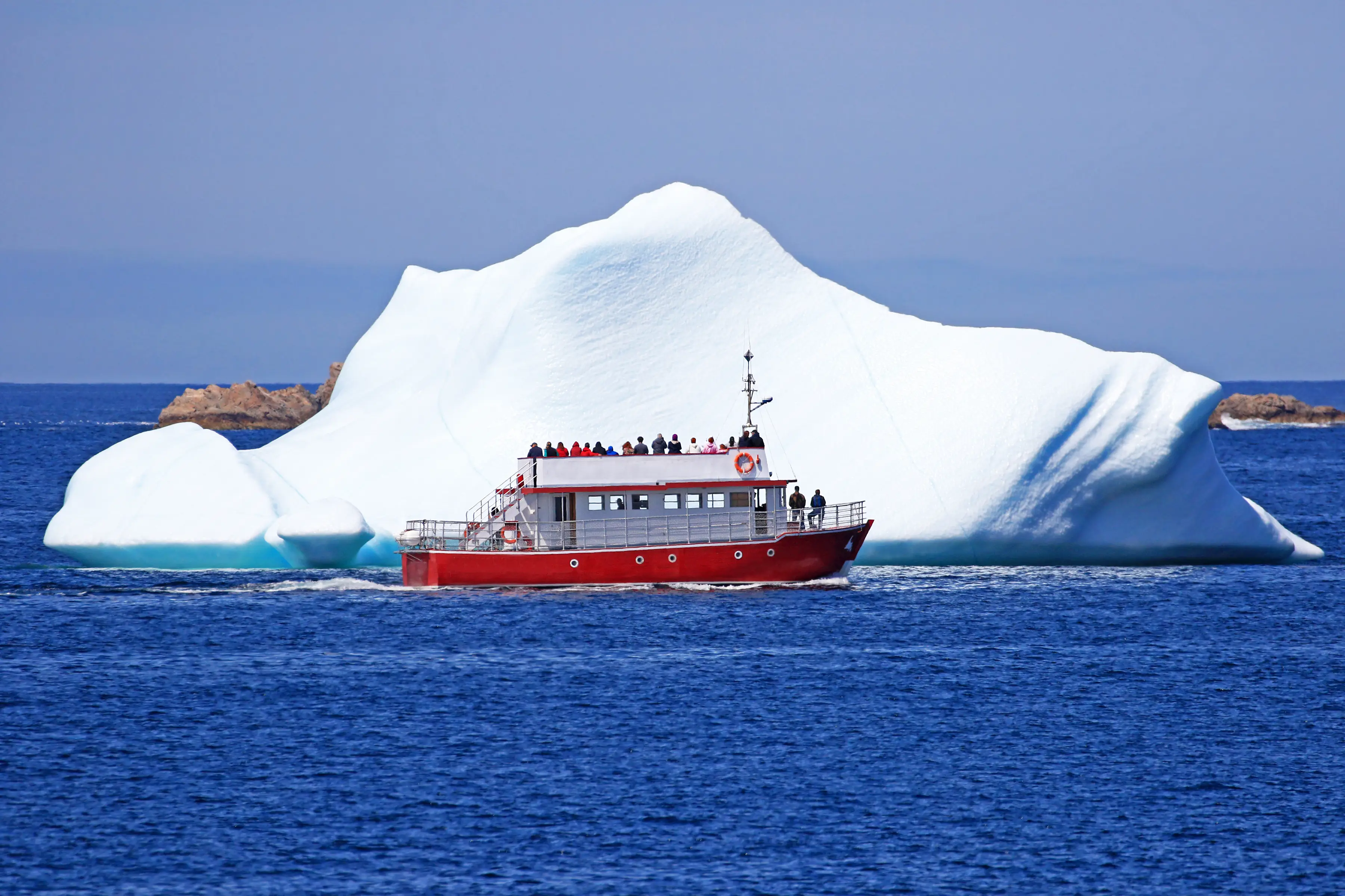 Kanada, Neufundland, Twillingate Ein Ausflugsboot fährt nahe an einem Eisberg in Twillingate, Neufundland, Kanada.