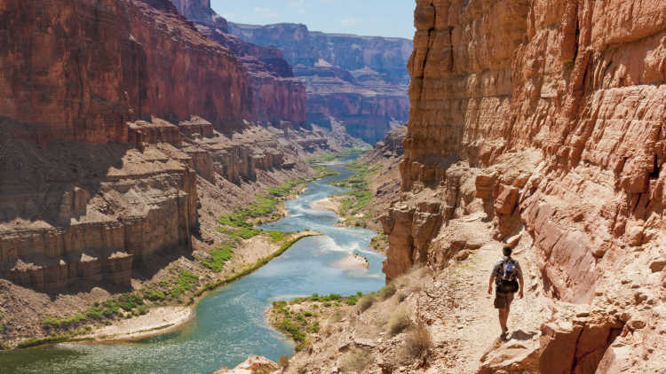 Un randonneur en train d'explorer le Grand Canyon par une journée ensoleillée. Découvrez ce parc lors de votre voyage aux Etats-Unis.