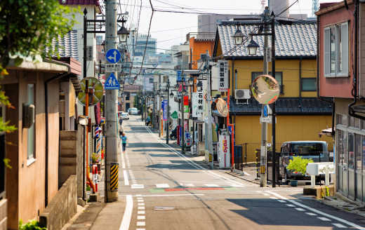 Rue d'un quartier résidentiel japonais avec des magasins, à Nagano, visitée lors d'un road trip.