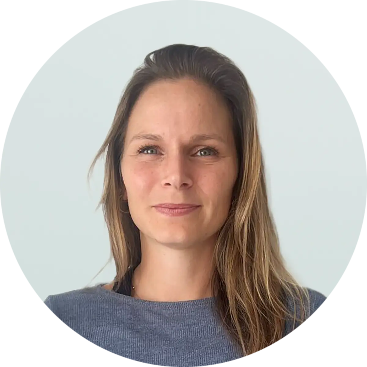 Laurine Calas Porträtfoto einer Person mit langen braunen Haaren in einem blauen Oberteil vor hellblauem Hintergrund in runder Rahmung.