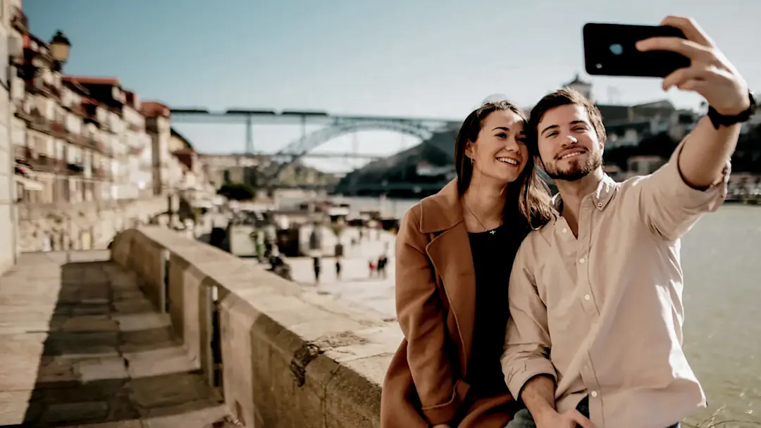 Ein junges Paar bei der Flussseite von Porto, Portugal.

