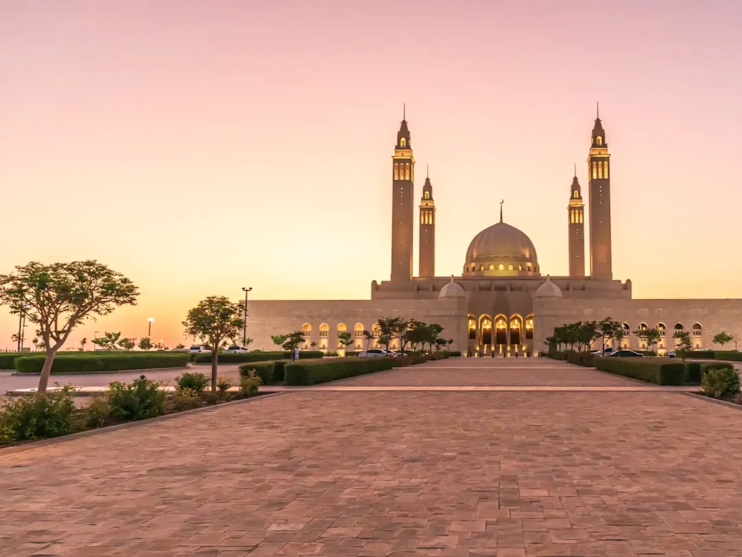 Große Moschee mit beleuchteten Minaretten in der Abenddämmerung. Maskat, Maskat, Oman.