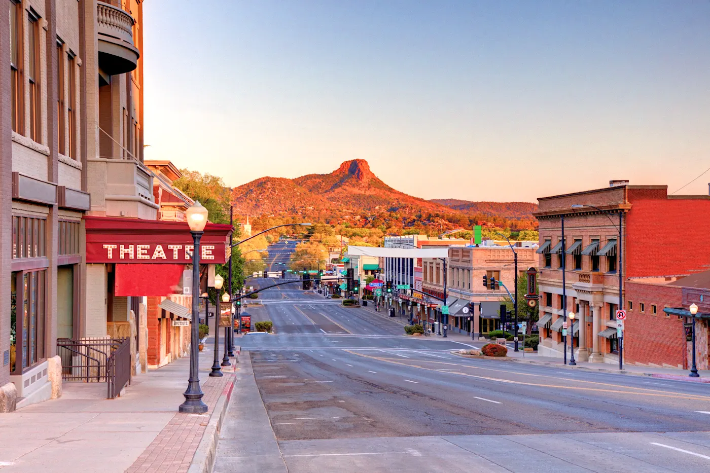 Arizona, USA Historische Innenstadt mit Geschäften und einem Theater unter einem dramatischen Abendhimmel mit Bergen. Prescott, Arizona, USA.