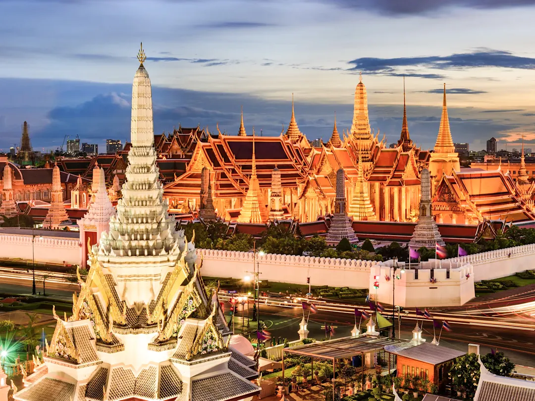 Beleuchtete buddhistische Tempelanlage bei Nacht. Großer Palast, Bangkok, Thailand.