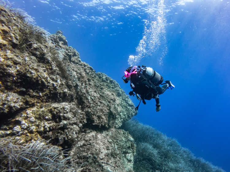 Frau, die an der Küste Italiens taucht