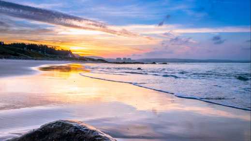 Blick auf einen Sonnenuntergang von einem Strand in Mossel Bay, Südafrika.