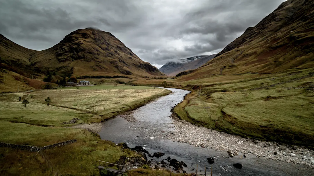 Blick auf grüne BerglandschaftPanoramablick auf das Tal von Glencoe mit einem Fluss und dramatischen Hügeln. Glencoe, Schottland, Vereinigtes Königreich.