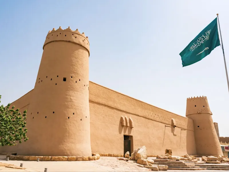 Riad, Riyadh, Saudi-Arabien Historisches Masmak-Fort mit saudischer Flagge und klarem Himmel. Riad, Riyadh, Saudi-Arabien.