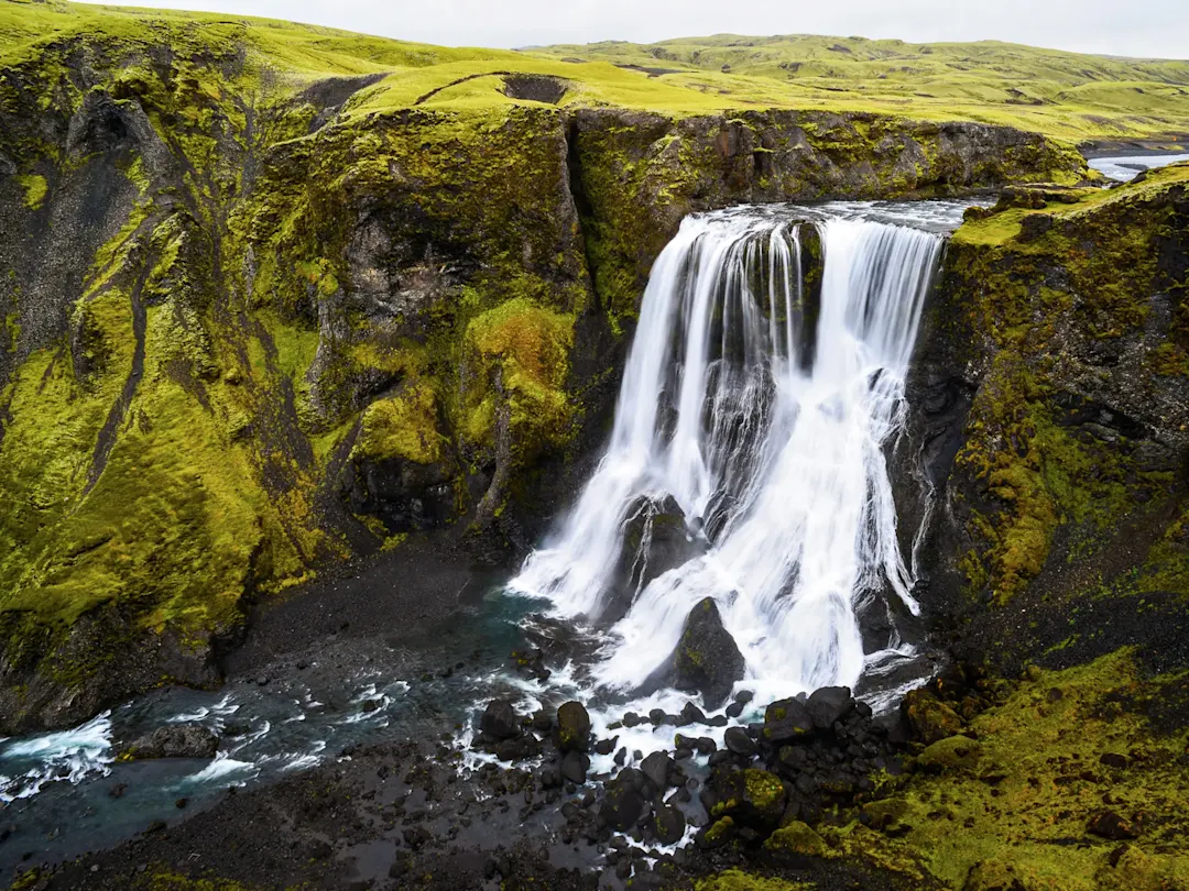 Malerischer Wasserfall mit moosbewachsenen Klippen. Fagrifoss, Südisland, Island.