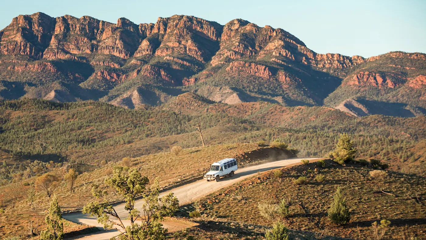 Australien, South Australia, Wilpena Pound, Ikara-Flinders Ranges National Park Ein Geländewagen fährt auf einer staubigen Straße durch die Flinders Ranges in Wilpena Pound, South Australia, Australien.