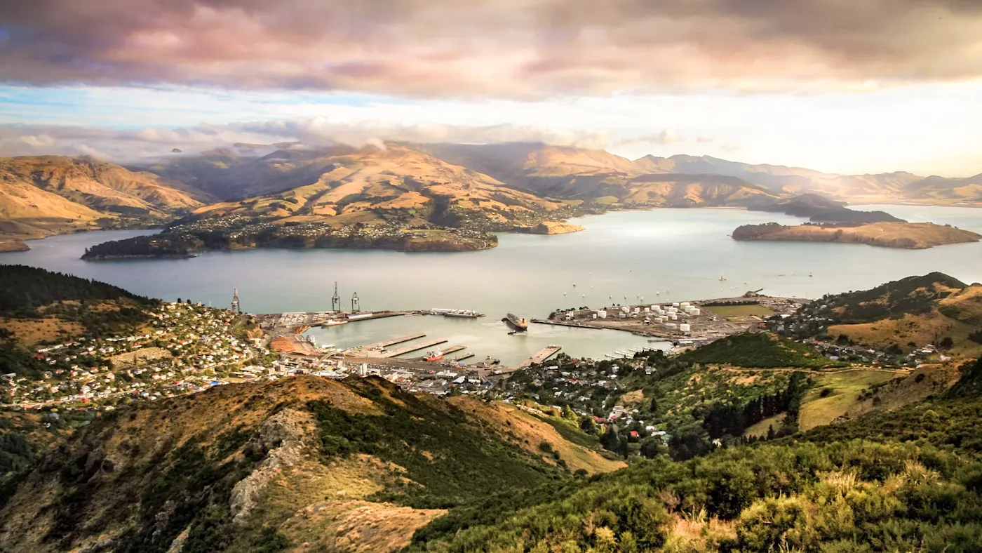 Christchurch, Südinsel, Neuseeland Panoramablick auf den Hafen von Lyttelton und die umliegenden Berge bei Sonnenuntergang. Christchurch, Südinsel, Neuseeland.