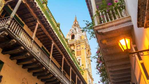 Blick zwischen zwei Häuserfasseden auf eine Kirche in Cartagena Kolumbien