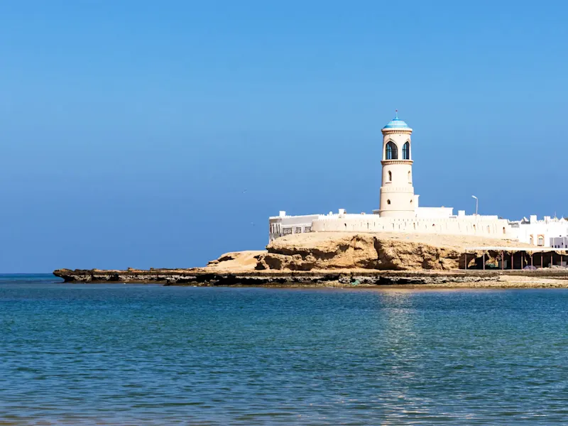 Historischer Leuchtturm an der Küste mit blauem Himmel. Sur, Ash Sharqiyah, Oman.
