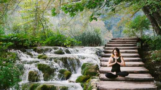 Jeune femme faisant du yoga dans un parc

