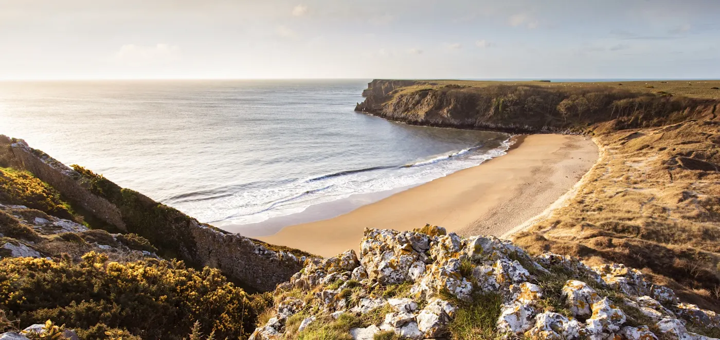 Malerischer Blick auf einen einsamen Sandstrand umgeben von Klippen. Pembrokeshire, Wales, Vereinigtes Königreich.