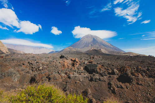 Pico do Fogo, Vulkan auf der Insel Fogo auf den Kapverdischen Inseln, mit etwas Gras und Felsen im Vordergrund.