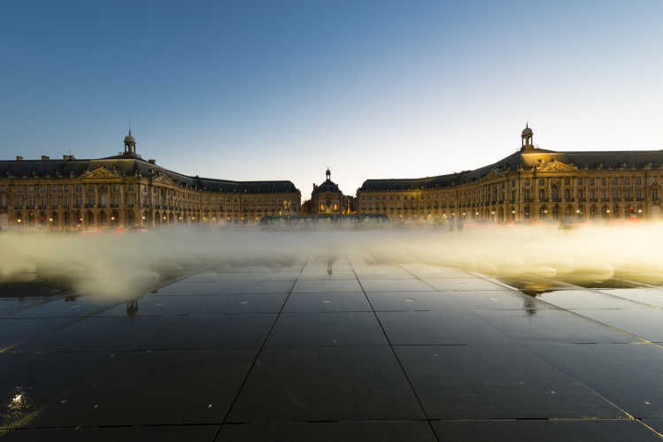 Besuchen Sie den Place de la Bourse, hier unter blauem Himmel, bei einem Urlaub in Bordeaux